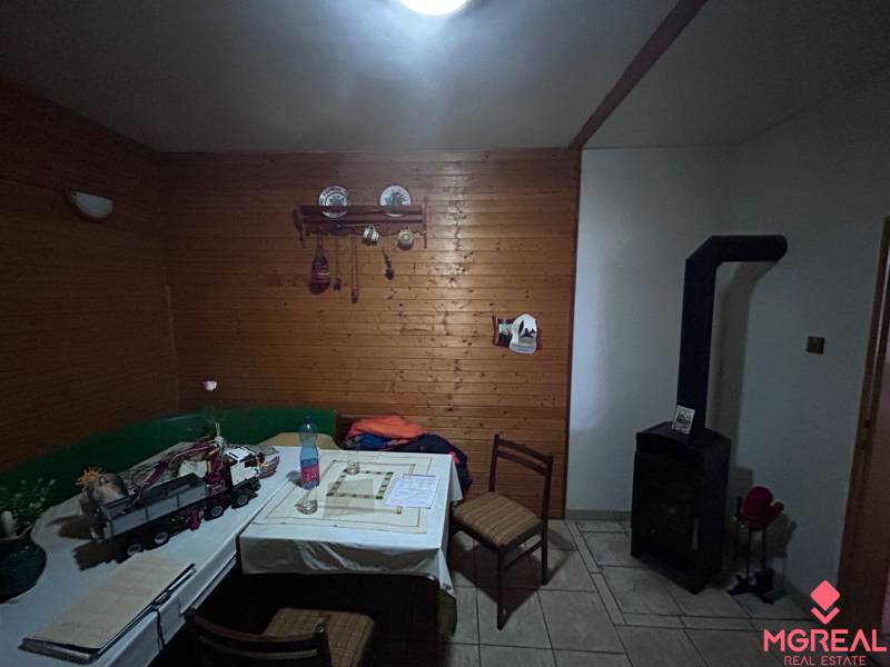 Ein Einfamilienhaus mit Holzverkleidung an den Wänden, Kacheln und einem Esstisch.