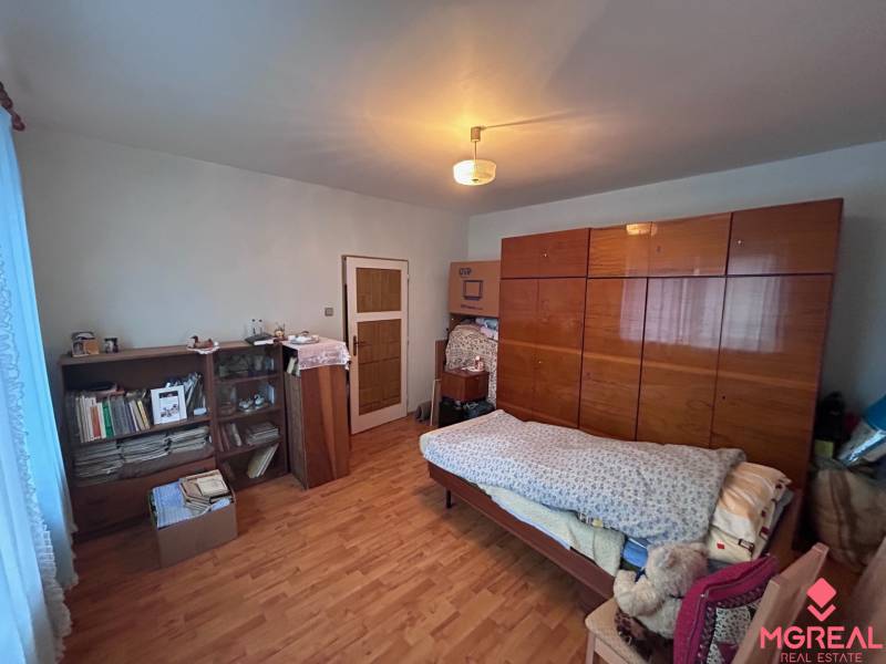 Schlafzimmer in einem Einfamilienhaus mit Bett, Schrank und Boden mit Holzdekor.