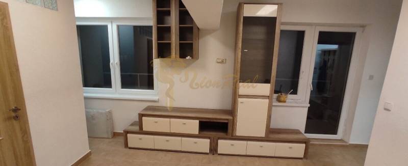 Wohnzimmer in einer Einzimmerwohnung mit Möbeln, Fenster und Boden in Holzoptik.