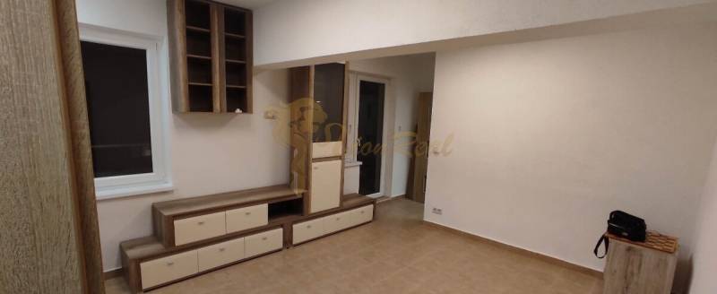 Wohnzimmer einer Einzimmerwohnung mit Möbeln und Boden in Holzoptik.