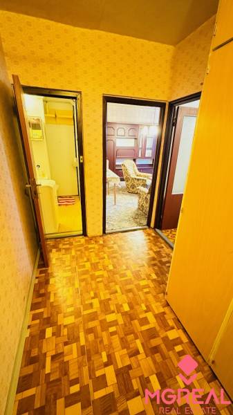 Flur in einer 2-Zimmer-Wohnung mit Holzboden und Türen zu den Zimmern.