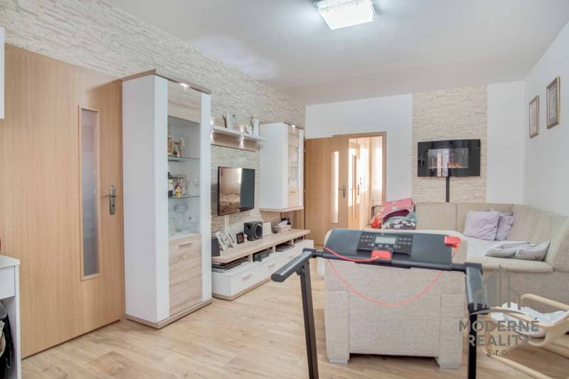 Wohnzimmer in einer 3-Zimmer-Wohnung mit Holzboden und Ecksofa.