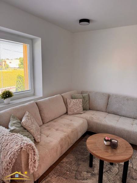 Ein bequemes Sofa und ein Couchtisch in einer 2-Zimmer-Wohnung mit Blick nach draußen.