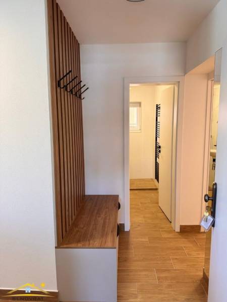 Eingangsflur mit Hängesystem und Boden in Holzoptik in einer 2-Zimmer-Wohnung.