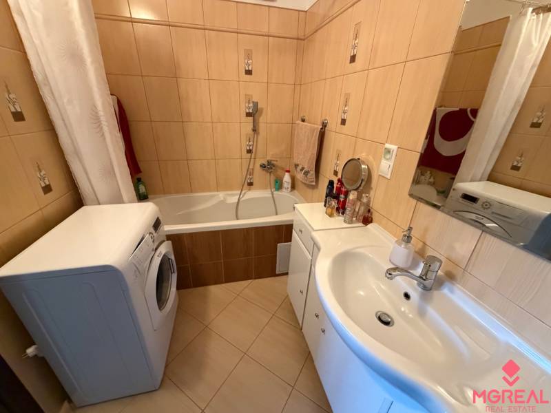 Badezimmer mit Dusche und Badewanne in einer 3-Zimmer-Wohnung, mit Waschmaschine und Waschbecken.