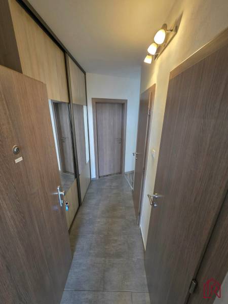 Flur in einer 2-Zimmer-Wohnung mit Fliesenboden und einem Einbauschrank mit Spiegeltüren.