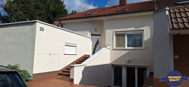 Ein Einfamilienhaus in Komárno mit weißer Fassade und rotem Dach.