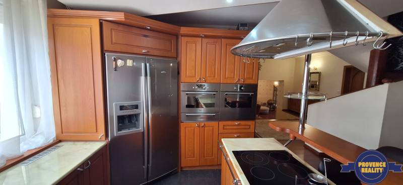 Küche in einem Einfamilienhaus mit Holzschränken und Edelstahlelektrogeräten.