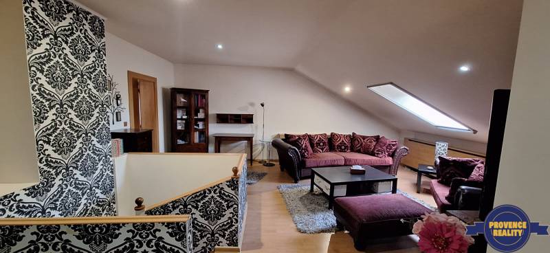 Wohnzimmer mit Sofas und gemusterten Wänden, Boden mit Holzdekor.