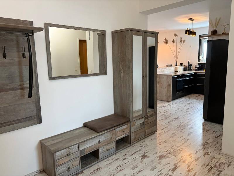 Flur mit Holzdekor und Blick in die Küche in einer 3-Zimmer-Wohnung.