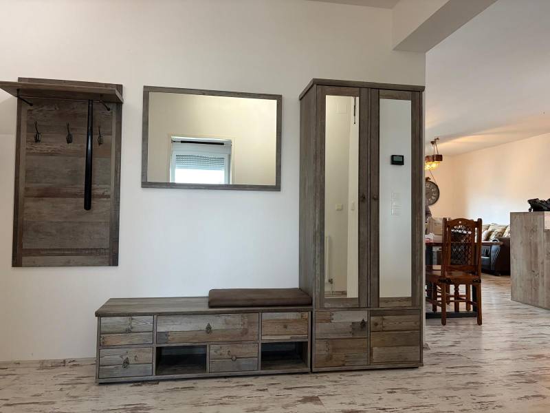 Flur in einer 3-Zimmer-Wohnung mit Garderobe und Schrank, Boden mit Holzdekor.