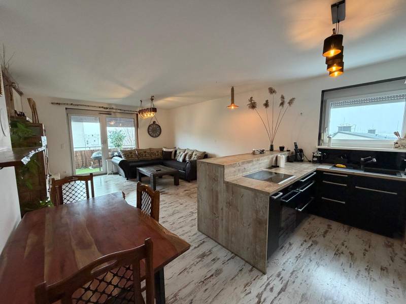 Wohnzimmer mit Küche in einer 3-Zimmer-Wohnung, Boden mit Holzdekor.