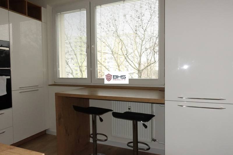 Küche einer 3-Zimmer-Wohnung mit Holzboden und großen Fenstern.