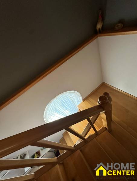 Eine Treppe mit Holzdekor in einem Einfamilienhaus mit Treppengeländer und rundem Fenster.