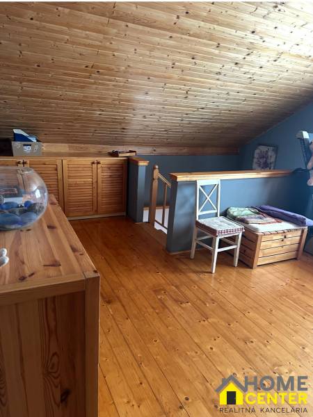 Das Dachgeschoss eines Einfamilienhauses mit einer Holzdecke, Wänden und einem Boden in Holzoptik.