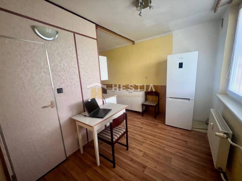 Küche in einer 3-Zimmer-Wohnung mit Schreibtisch, Kühlschrank und Holzboden.