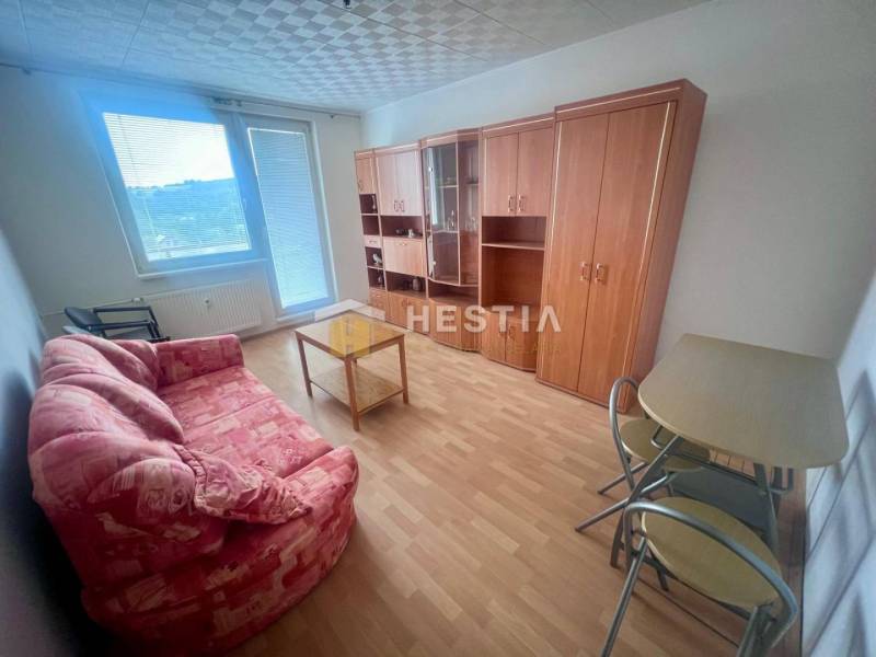 Wohnzimmer in einer 3-Zimmer-Wohnung mit Sofa, Tisch und Schrank, hellem Boden.