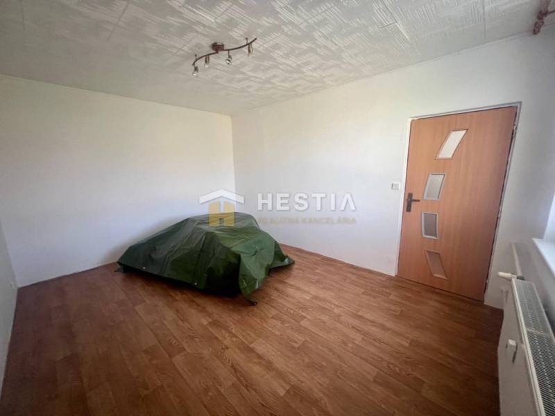 Ein Zimmer in einer 3-Zimmer-Wohnung mit Boden, Heizkörper, Türen und einfacher Beleuchtung.