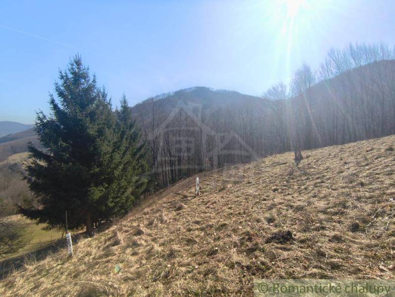 Ein sonniges Grundstück in den Gärten von Nová Baňa, umgeben von Wäldern und Bergen.