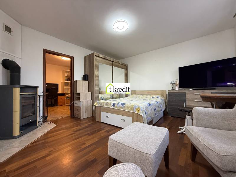 Innenraum eines Zimmers mit Holzboden und Kamin in einer Zweizimmerwohnung.