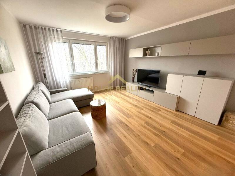 Wohnzimmer einer 3-Zimmer-Wohnung mit Sofa und Holzboden.