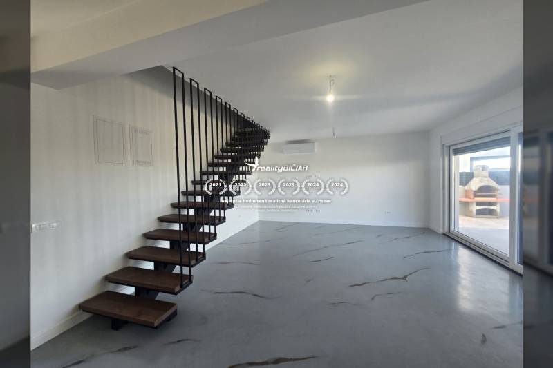 Innenraum der Villa mit Metalltreppe und Holzboden, großes Fenster zur Terrasse.