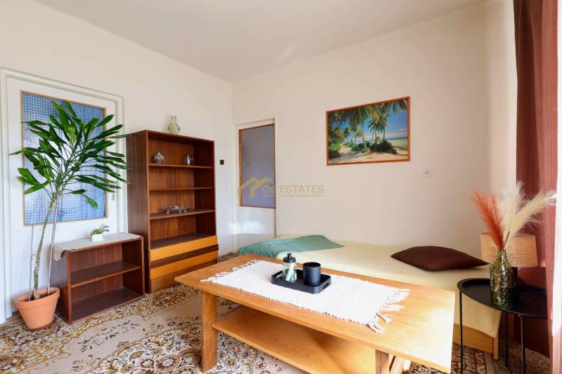 Wohnzimmer in einem Einfamilienhaus mit Teppichboden, Holzmöbeln und einem Strandbild.