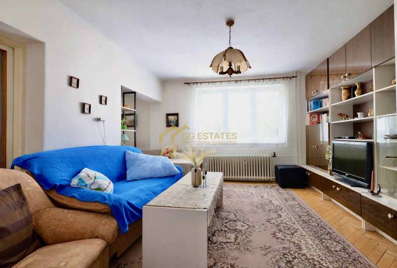 Wohnzimmer in einem Einfamilienhaus mit Teppichmuster und Wohnwand.