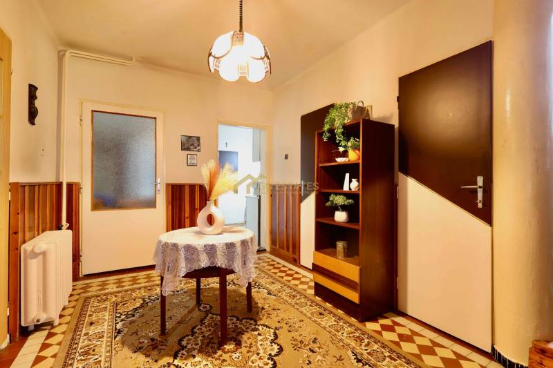 Innenraum eines Einfamilienhauses mit Teppichboden, im Hintergrund ein Schrank und Beleuchtung.