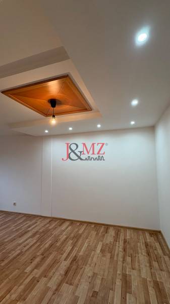 Deckenlampe und Boden mit Holzdekor in einer Zweizimmerwohnung.