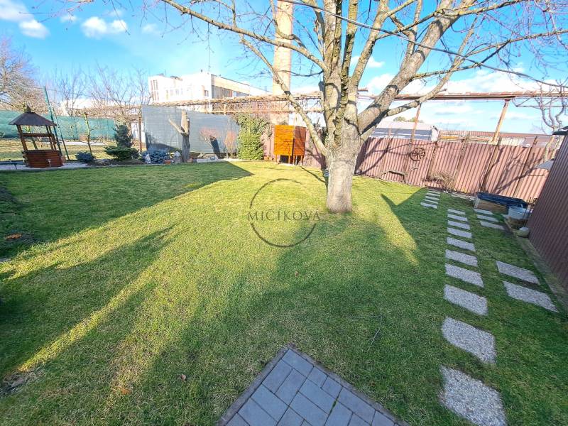 Gärten in Dolné Krškany, Nitra mit Kamin, Baum, Rasen und Sonnenschutz.