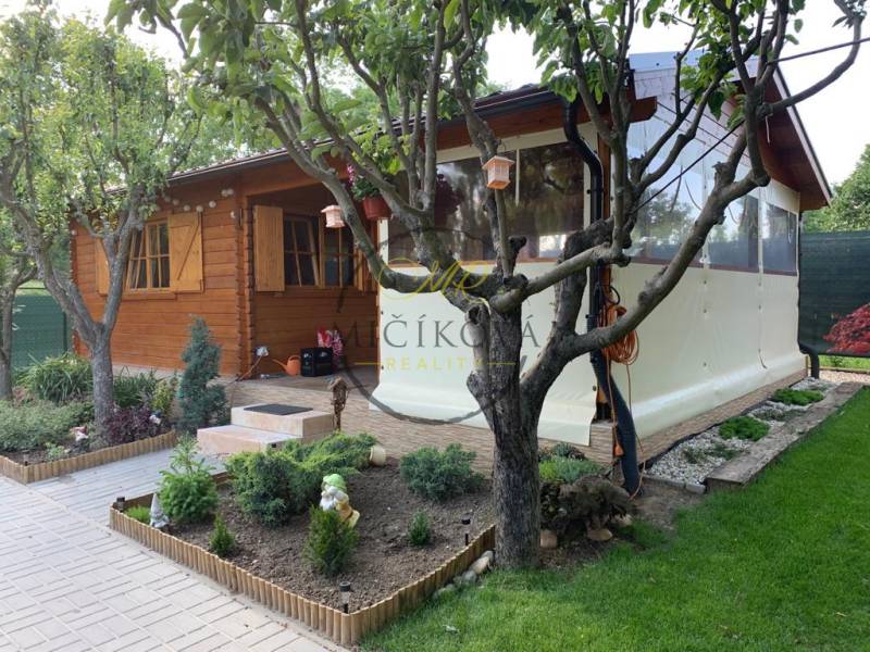 Ein hölzernes Gartenhaus umgeben von Grün in den Gärten von Dolné Krškany in Nitra.