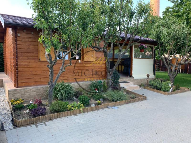 Gärten in Dolné Krškany bei Nitra mit einer Holzhütte und einem gestalteten Erholungsbereich.