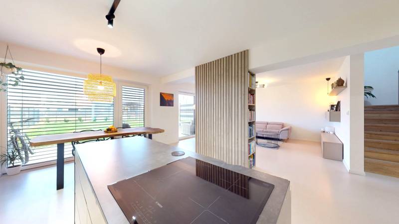 Offenes Interieur eines Einfamilienhauses mit Küche, Essbereich und gemütlicher Wohnecke.