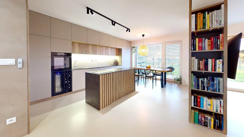 Offene Küche mit Esstisch und Bücherregal in einem Einfamilienhaus.