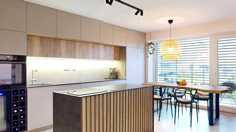 Küche in einem Einfamilienhaus mit Holzmöbeldekor und großen Fenstern.