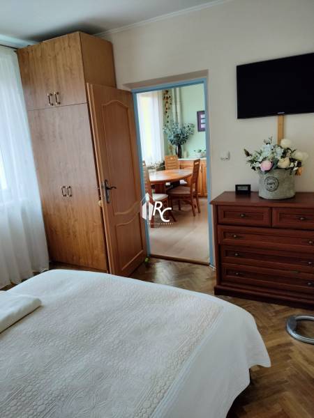 Schlafzimmer mit Einbauschrank in einer 2-Zimmer-Wohnung, Boden mit Holzdekor, Türen führen in die Küche.