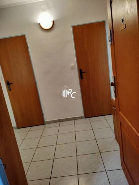 Eingangsflur in einer 2-Zimmer-Wohnung mit Fliesenboden und Holztüren.