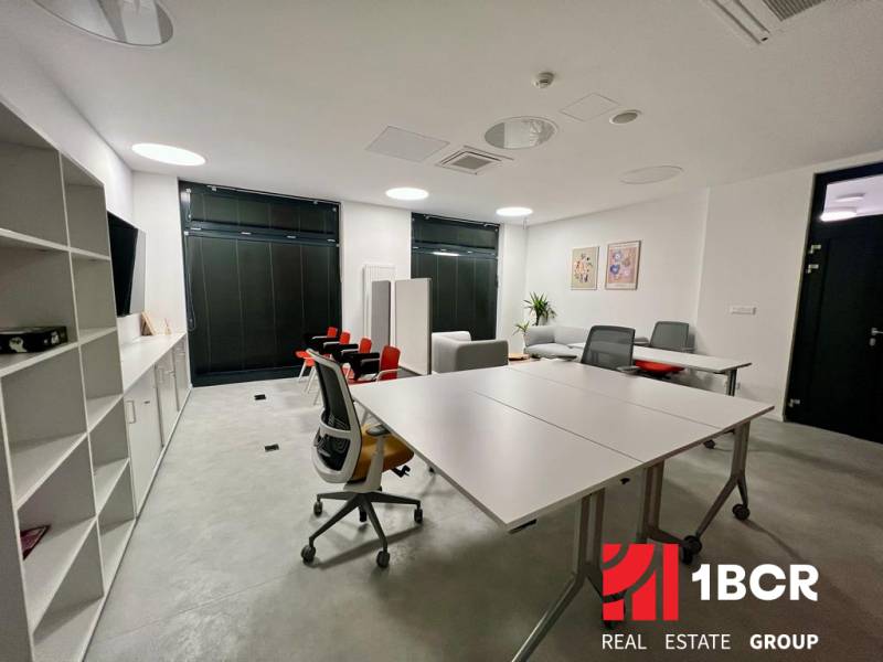 Ein Büro mit weißen Möbeln, zwei Schreibtischen und Regalen in einer 2-Zimmer-Wohnung.