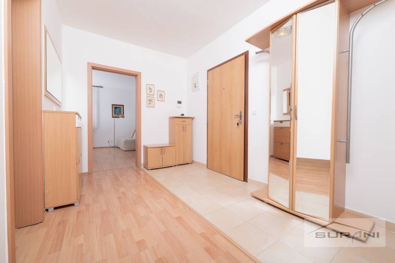 Eingangsbereich in einer 3-Zimmer-Wohnung mit Holzboden und Spiegelschrank.