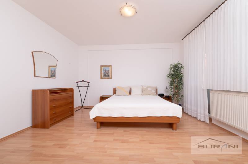 Schlafzimmer mit Bett, Kommode und Holzboden in einer 3-Zimmer-Wohnung.