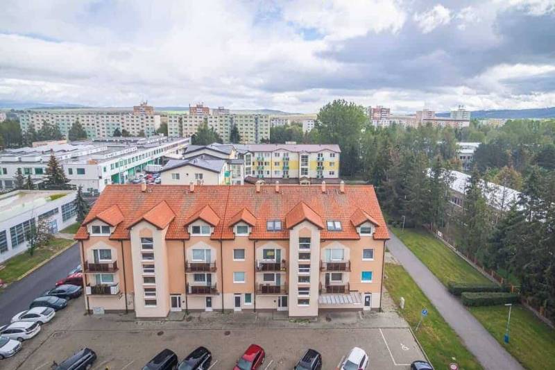 Ein Wohnhaus mit orangem Dach in Poprad bietet Aussicht auf die Umgebung, einschließlich 2-Zimmer-Wohnungen.