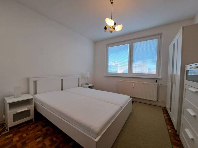 Helles Schlafzimmer in einer 2-Zimmer-Wohnung mit Holzboden.