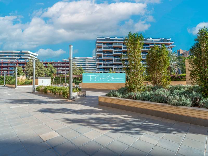 Moderne Architektur in Alicante mit Blick auf eine 2-Zimmer-Wohnung, umgeben von Grünflächen.
