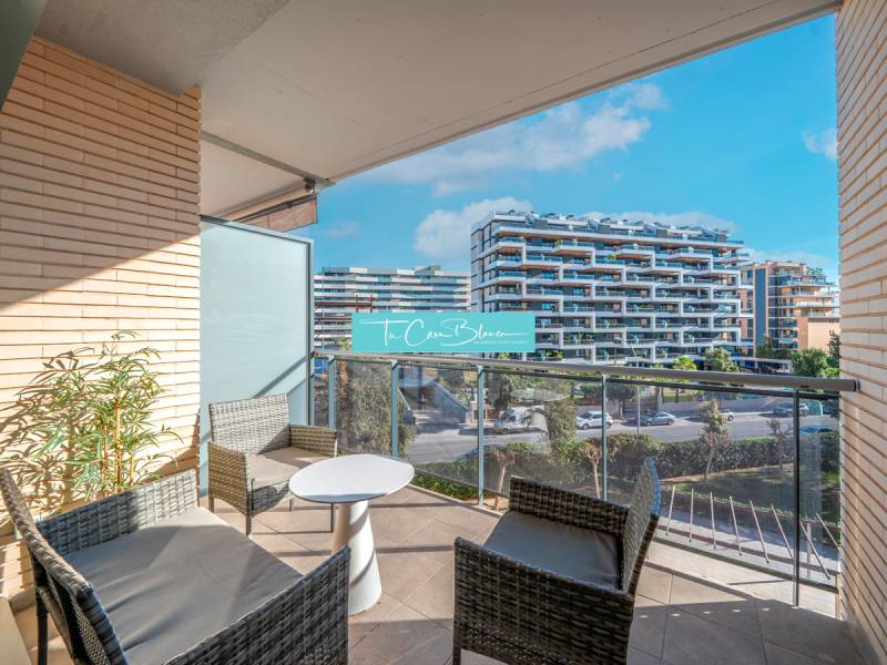 Balkon einer 2-Zimmer-Wohnung in Alicante mit Außenmöbeln und Blick auf moderne Gebäude.