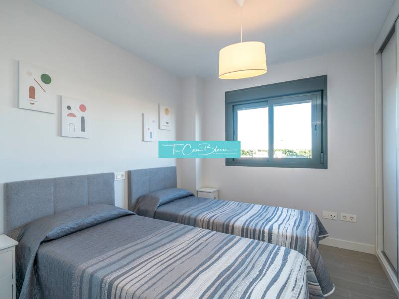 Zwei Einzelbetten in einer 2-Zimmer-Wohnung mit Fenster und dekorativen Bildern an der Wand.