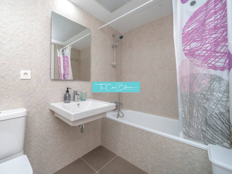 Badezimmer in einer 2-Zimmer-Wohnung mit modernen Fliesen, Badewanne und Waschbecken.