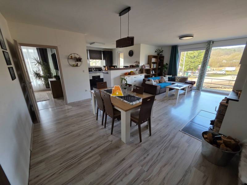 Wohnzimmer eines Einfamilienhauses mit offener Küche und Holzboden.