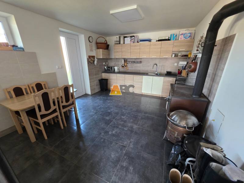 Küche in einem Einfamilienhaus mit Küchenzeile, Esstisch und Herd.