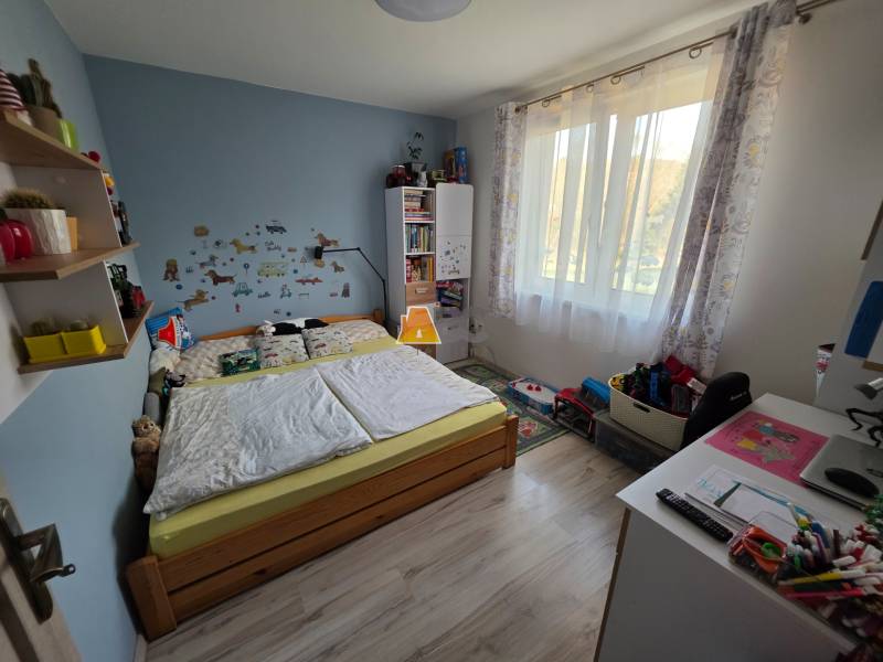 Kinderzimmer in einem Einfamilienhaus mit Holzboden, Bett und Spielzeug.